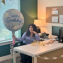 a woman holding a birthday balloon