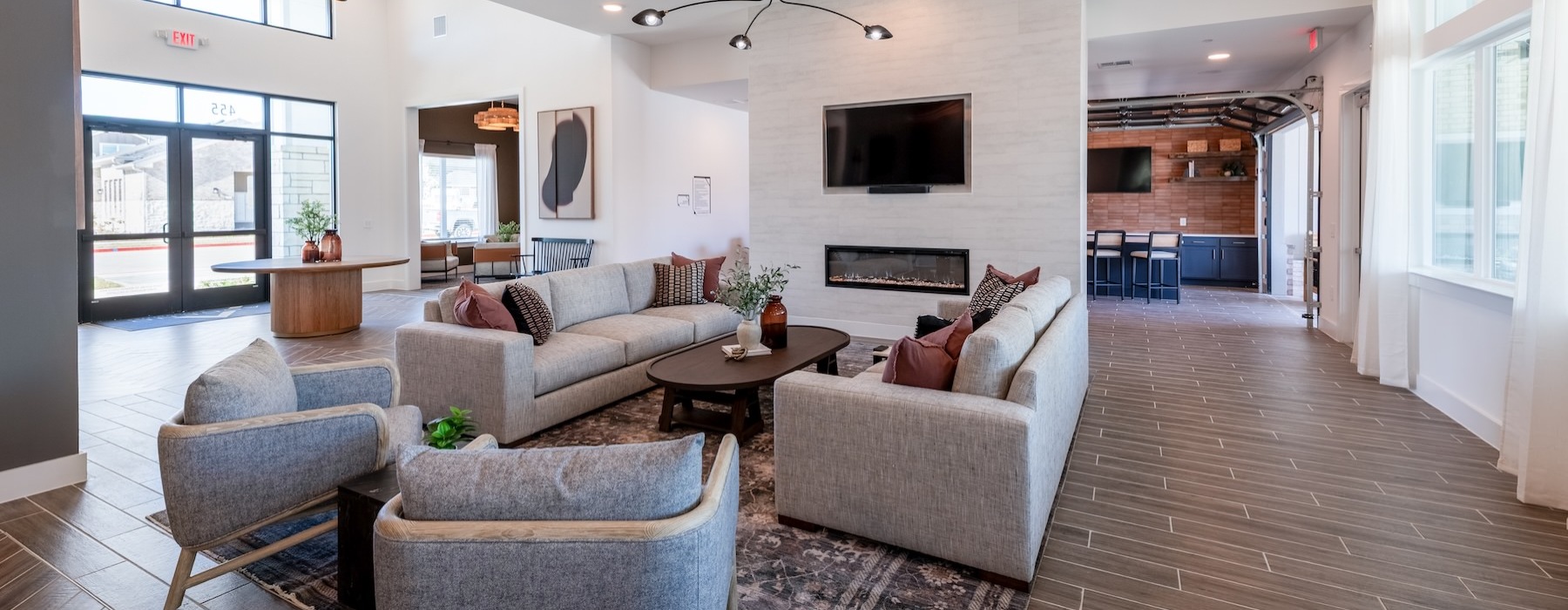 a clubroom with a tv, fireplace, couches and chairs